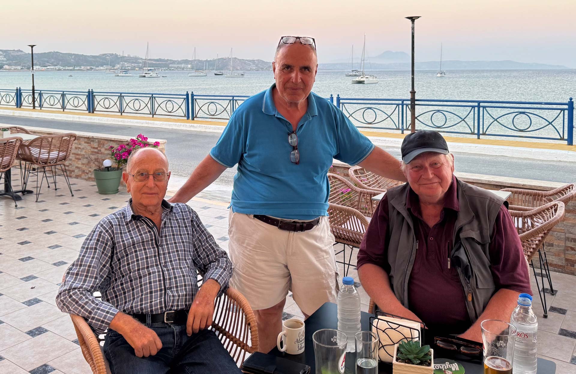 2026-06-30 Kos Kefalos Kamari Babis, Vasilis und ich im Sunlight. Die Blodughadda rechts von Vasilis' Kopf.